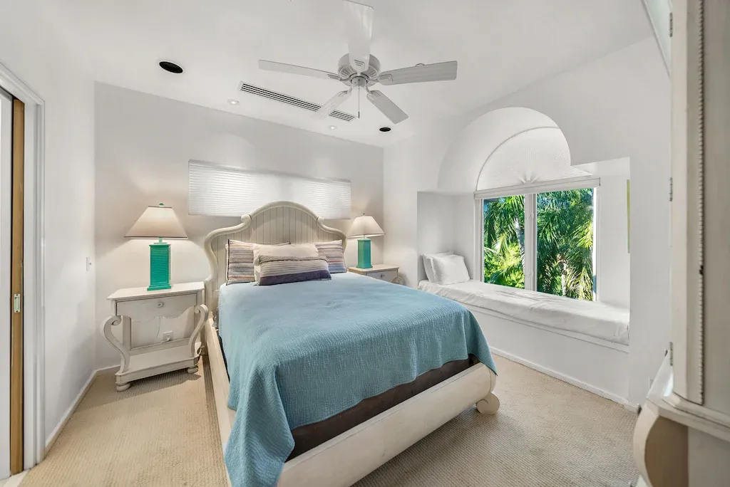 Bedroom with a bed, nightstands, and a large window with a built-in seating area.