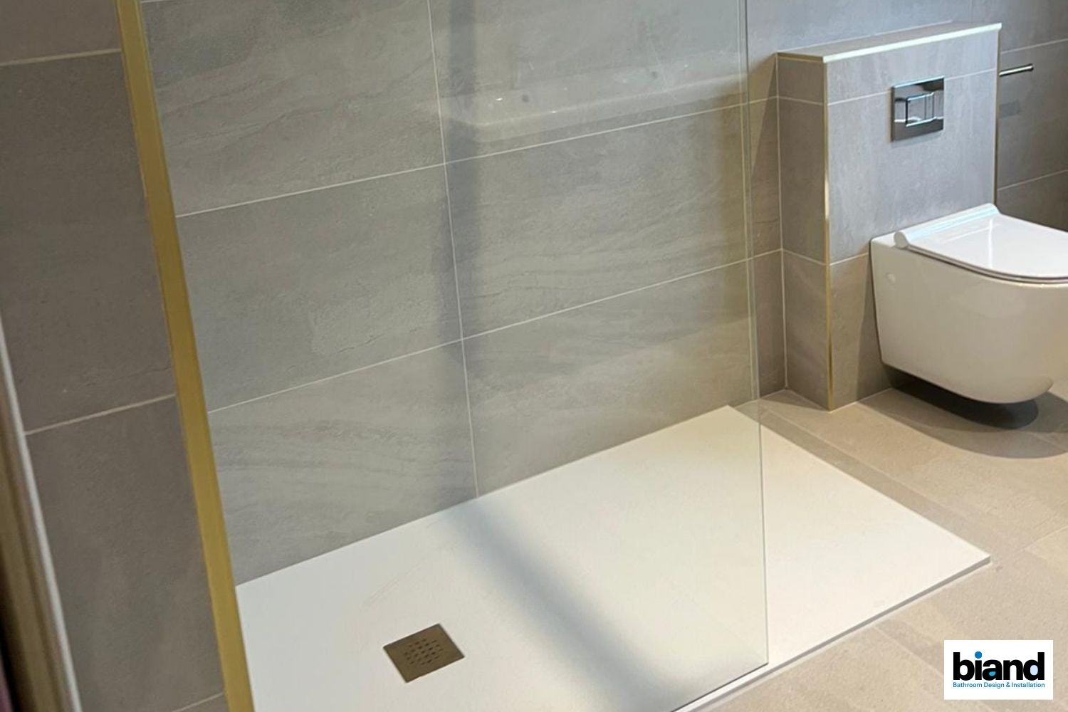 Bathroom with white shower base, tiled walls, and a wall-hung toilet.