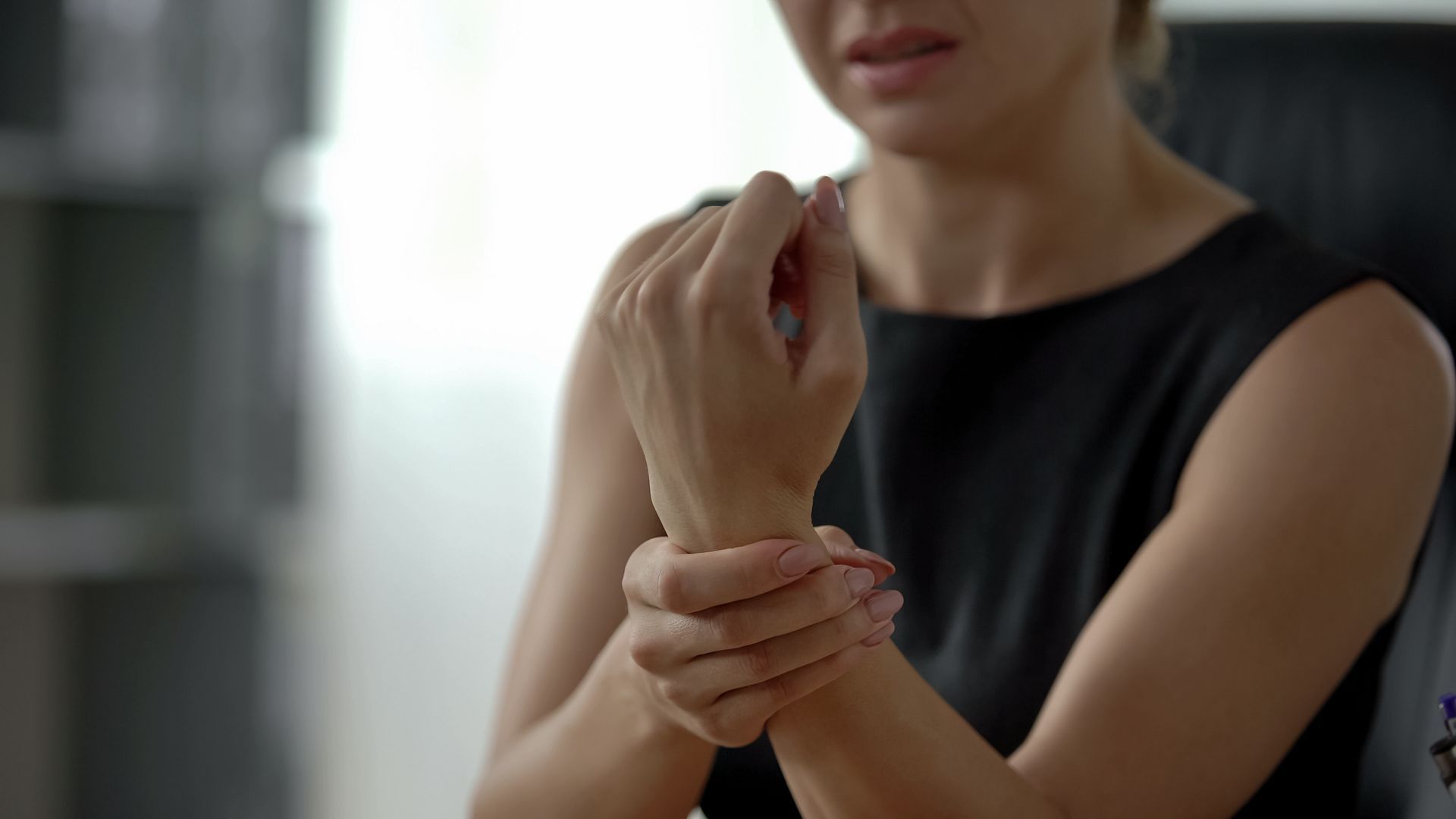Woman holding her sore wrist.