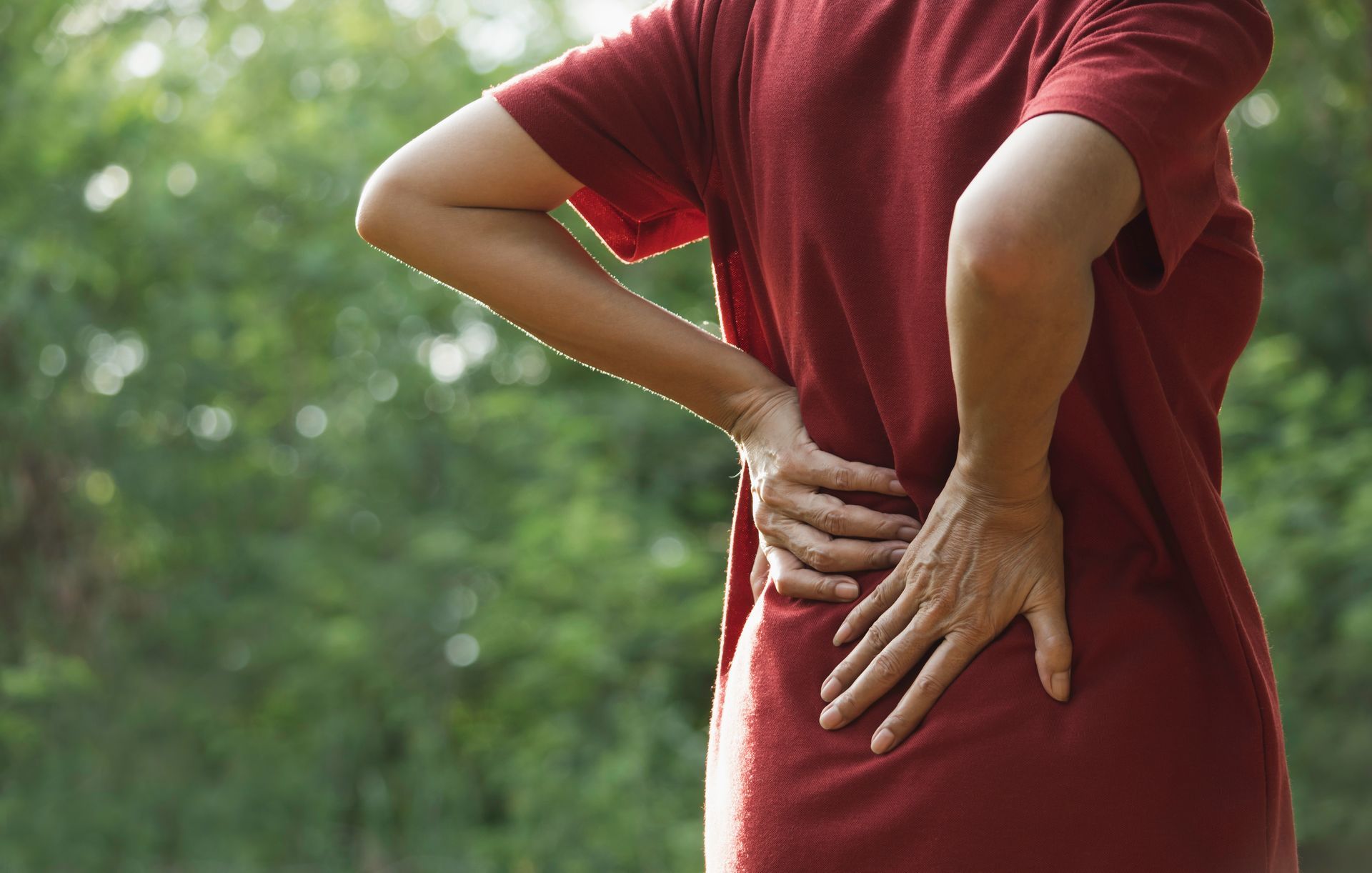 Person holding their lower back in pain.
