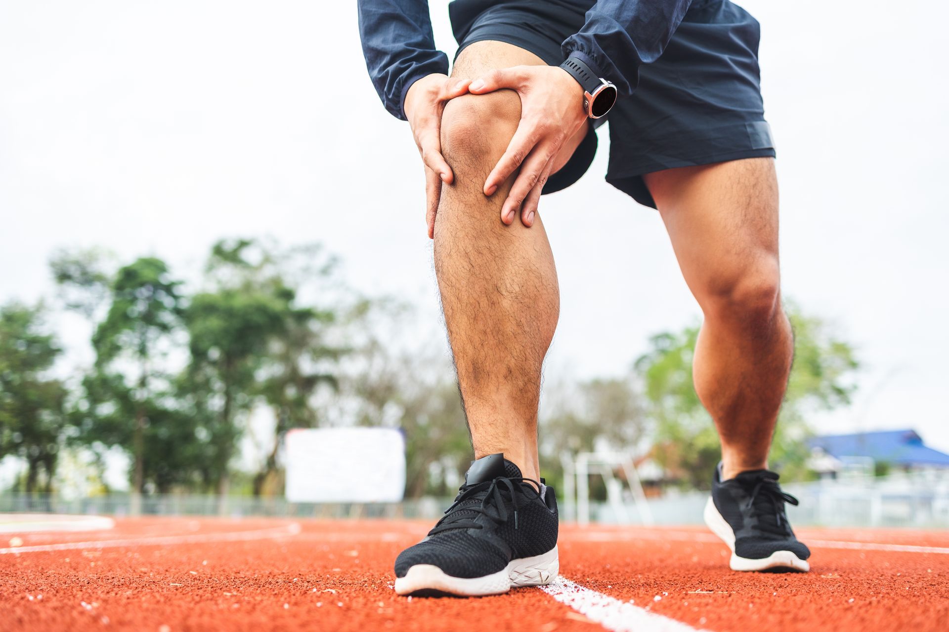 A man with sore knee running.