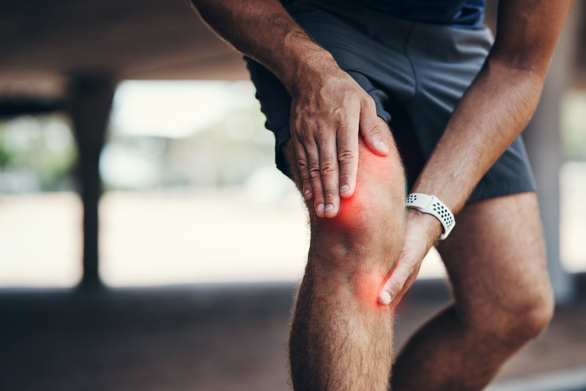 Man holding his sore knee.