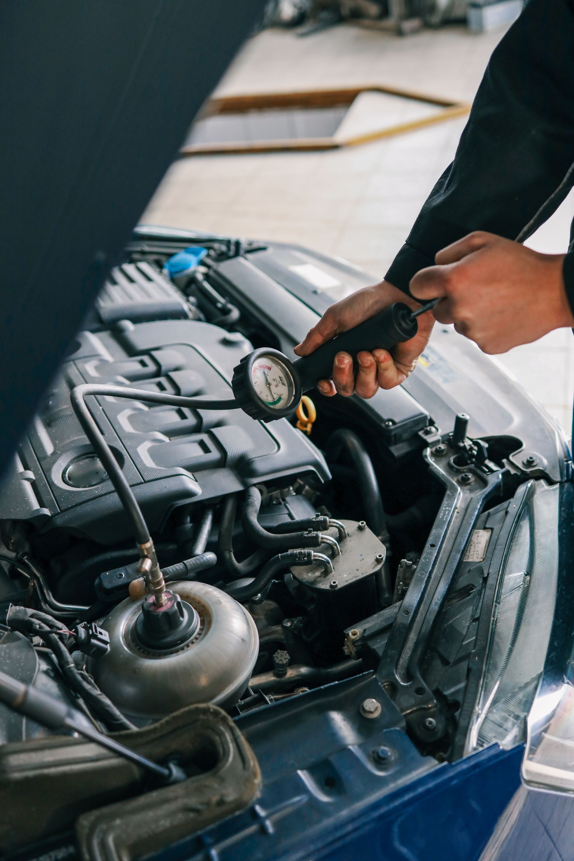Mechanic inspecting a car engine with a stethoscope in a garage