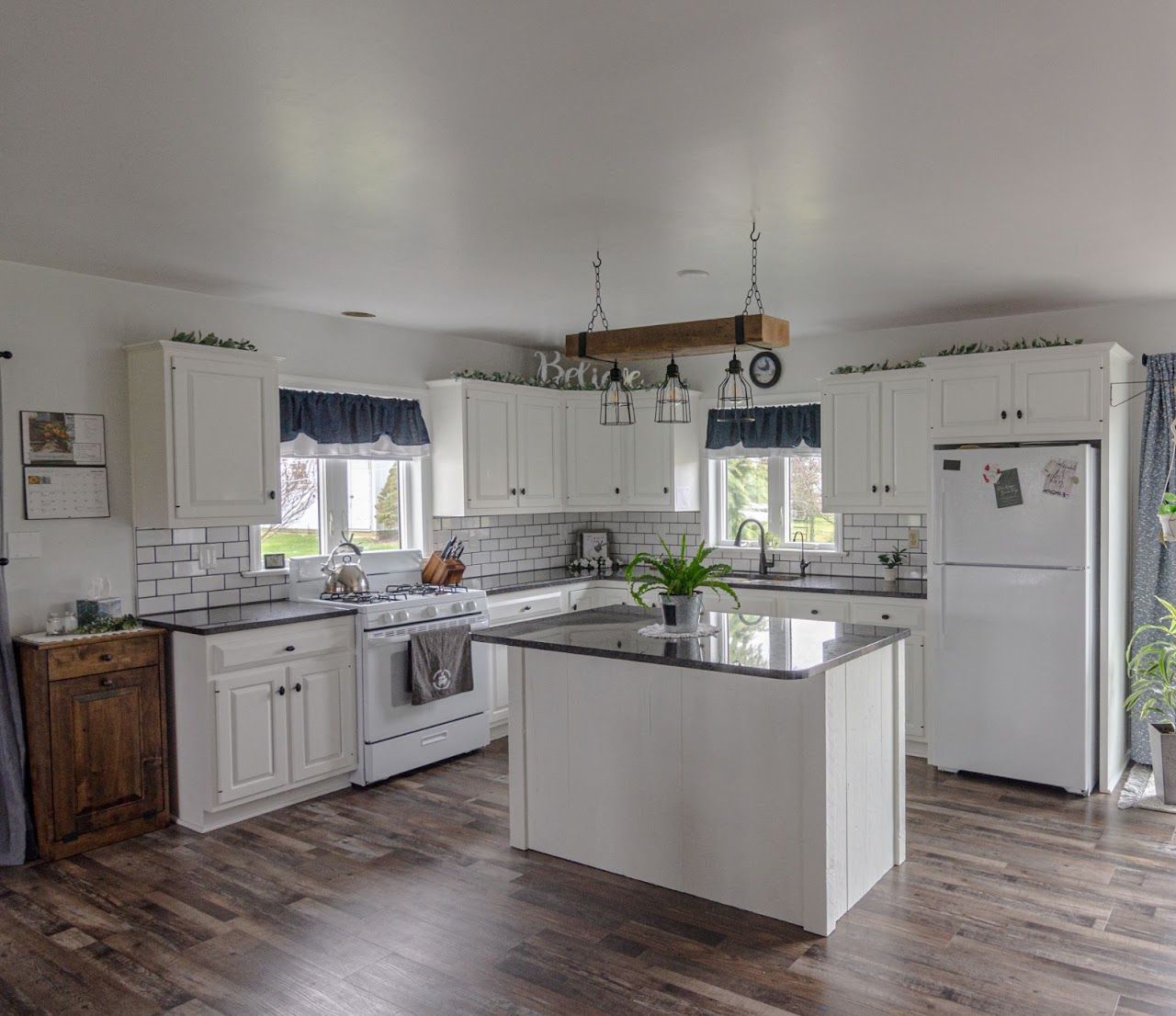 A kitchen with white cabinets and a large island in the middle.