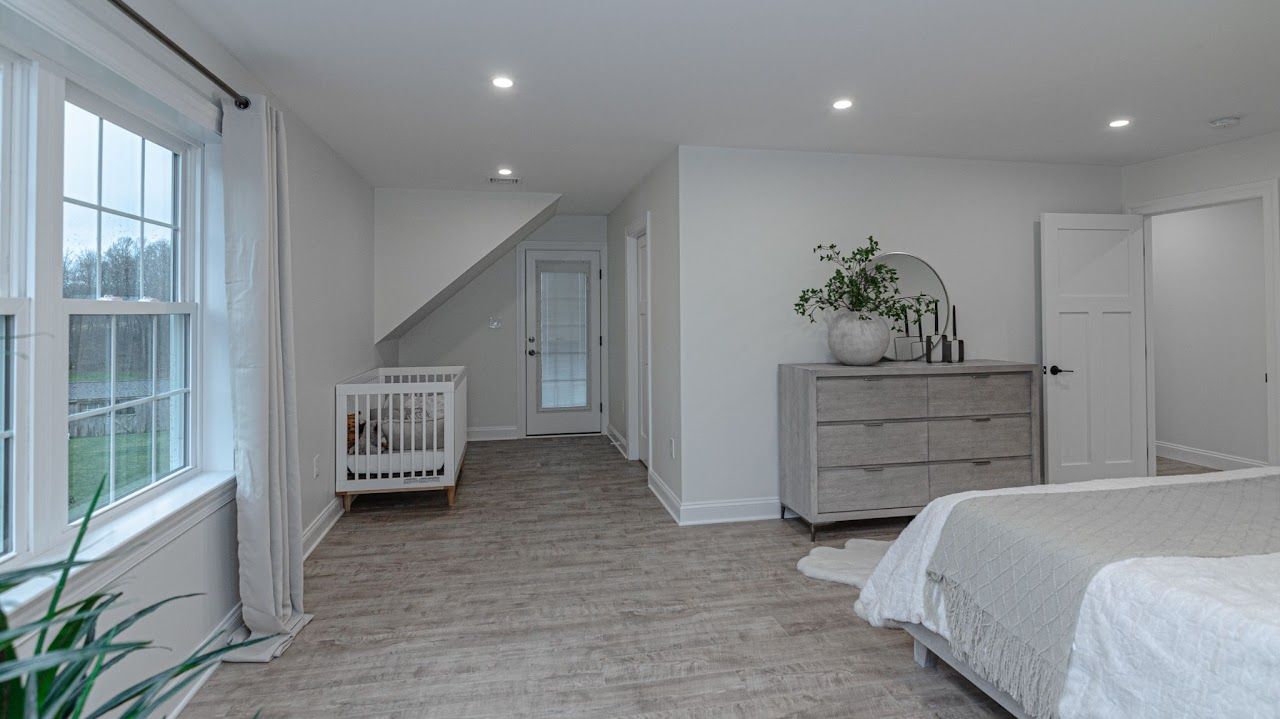 A bedroom with a bed , dresser , and a crib.