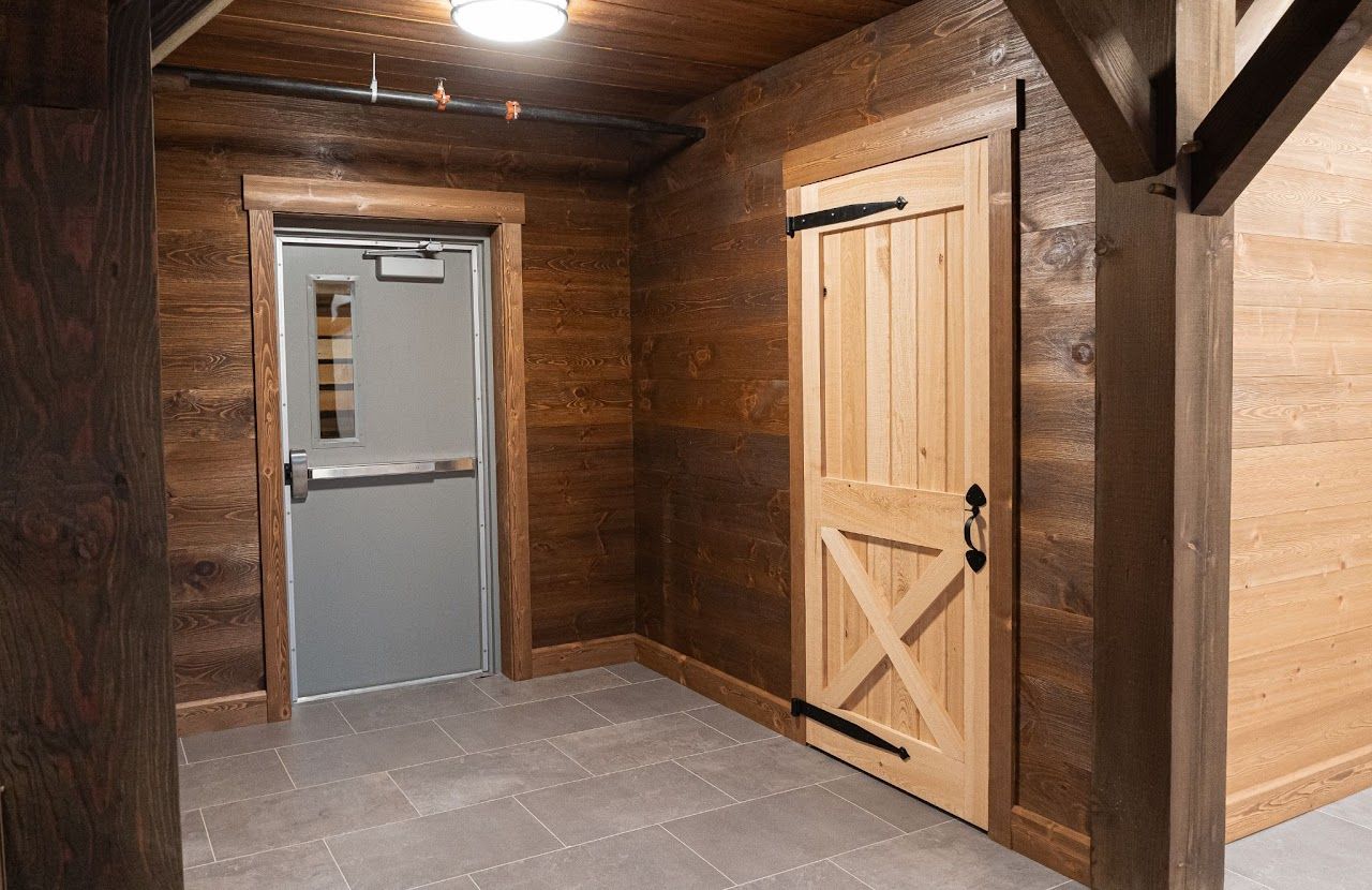 A wooden door with a red rug underneath it in a room.