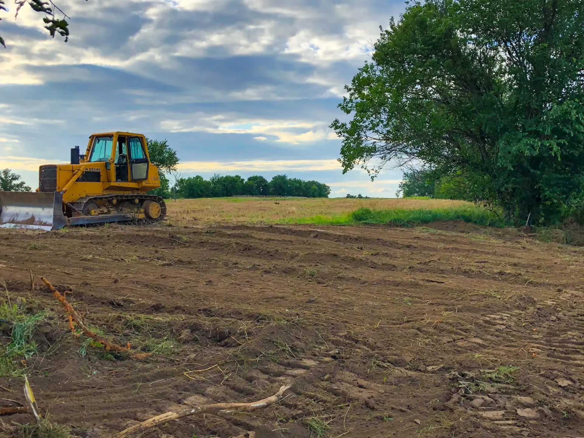 Bulldozer clearing trees in a field for a land clearing serving near Davenport, Iowa. 