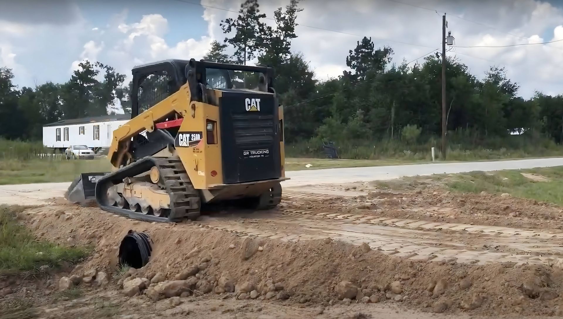 A trackloader installing a driveway culvert in rural Scotty County Iowa.