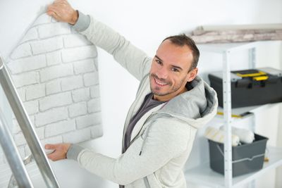 Person applying window film to a white-framed window indoors