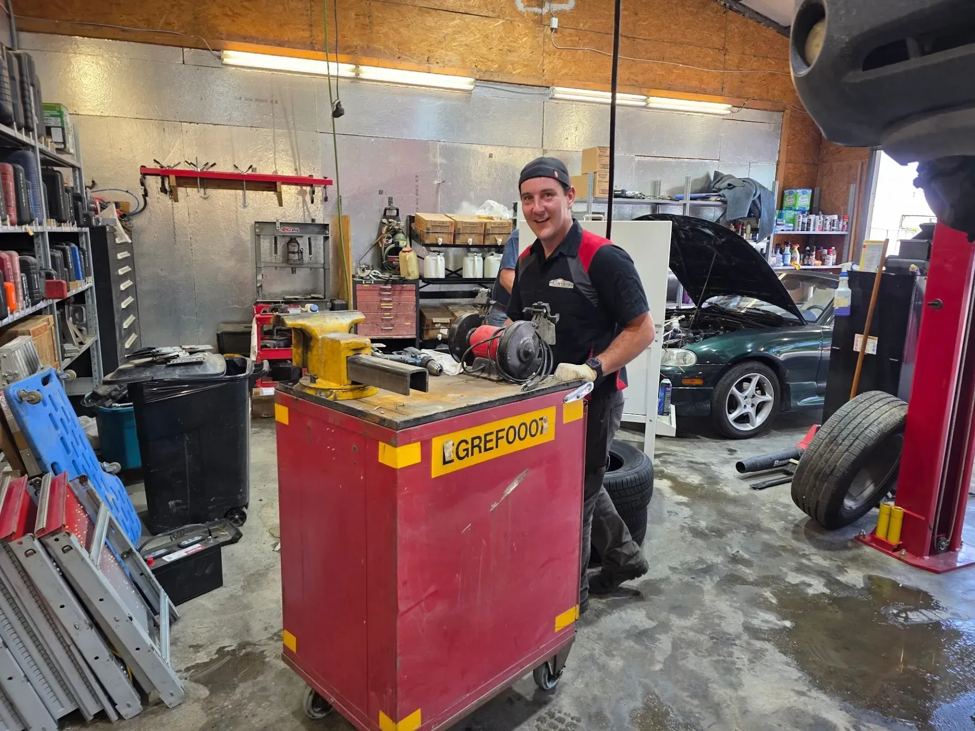 Mechanic Smiling Beside Red Tool Cart | Masters Auto Group