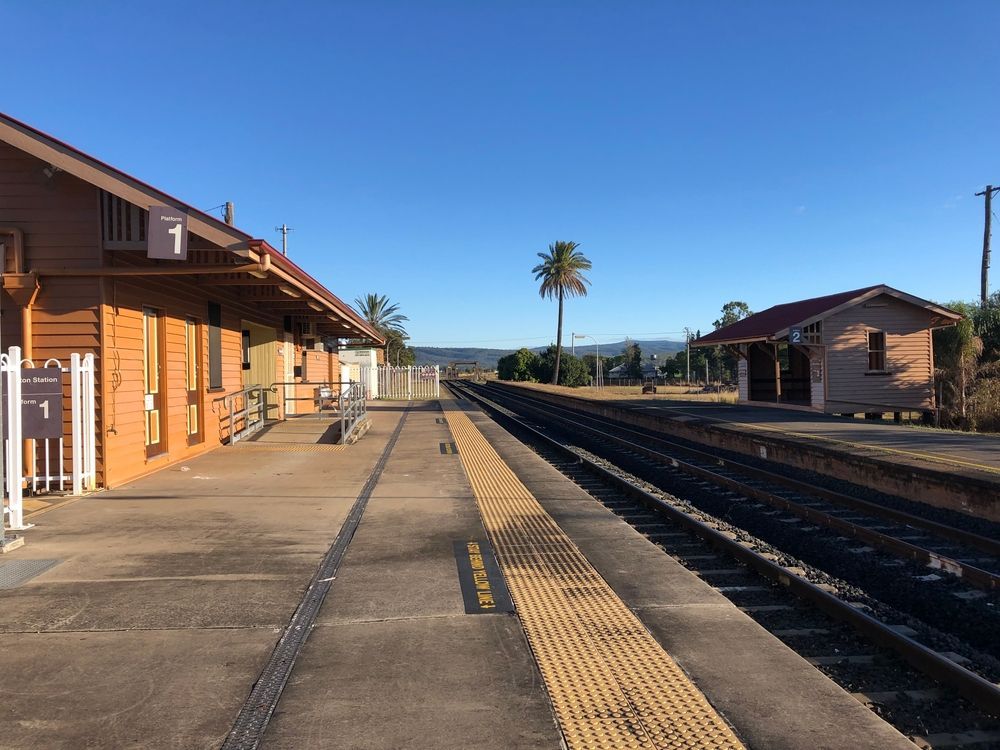 Railroad Station Platform With Brown Buildings, Tracks, and Blue Sky — Frontier Security in Gatton, QLD