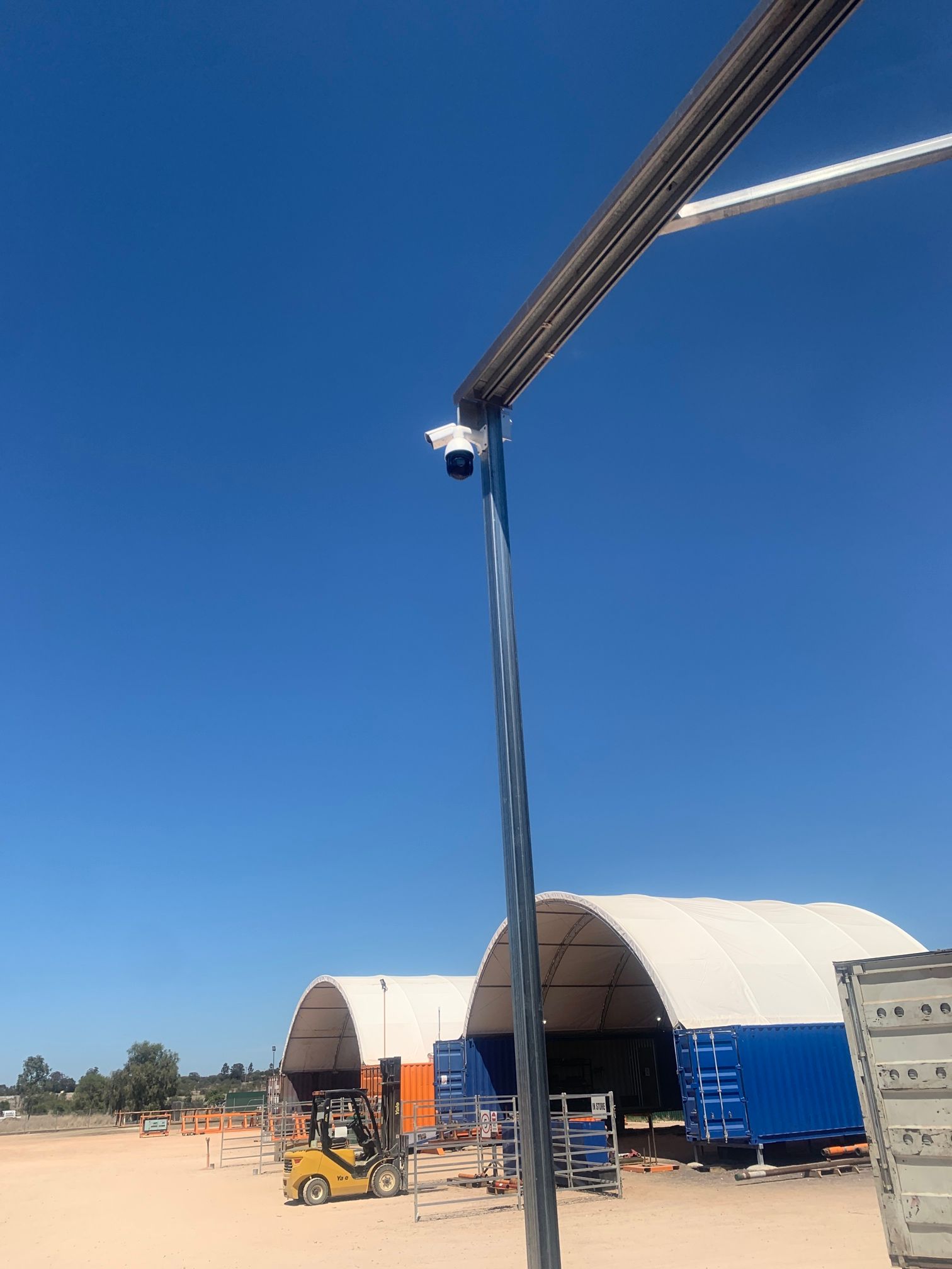 Security Camera on Pole, Overlooking a Construction Site With Blue Sky — Frontier Security in Chinchilla, QLD