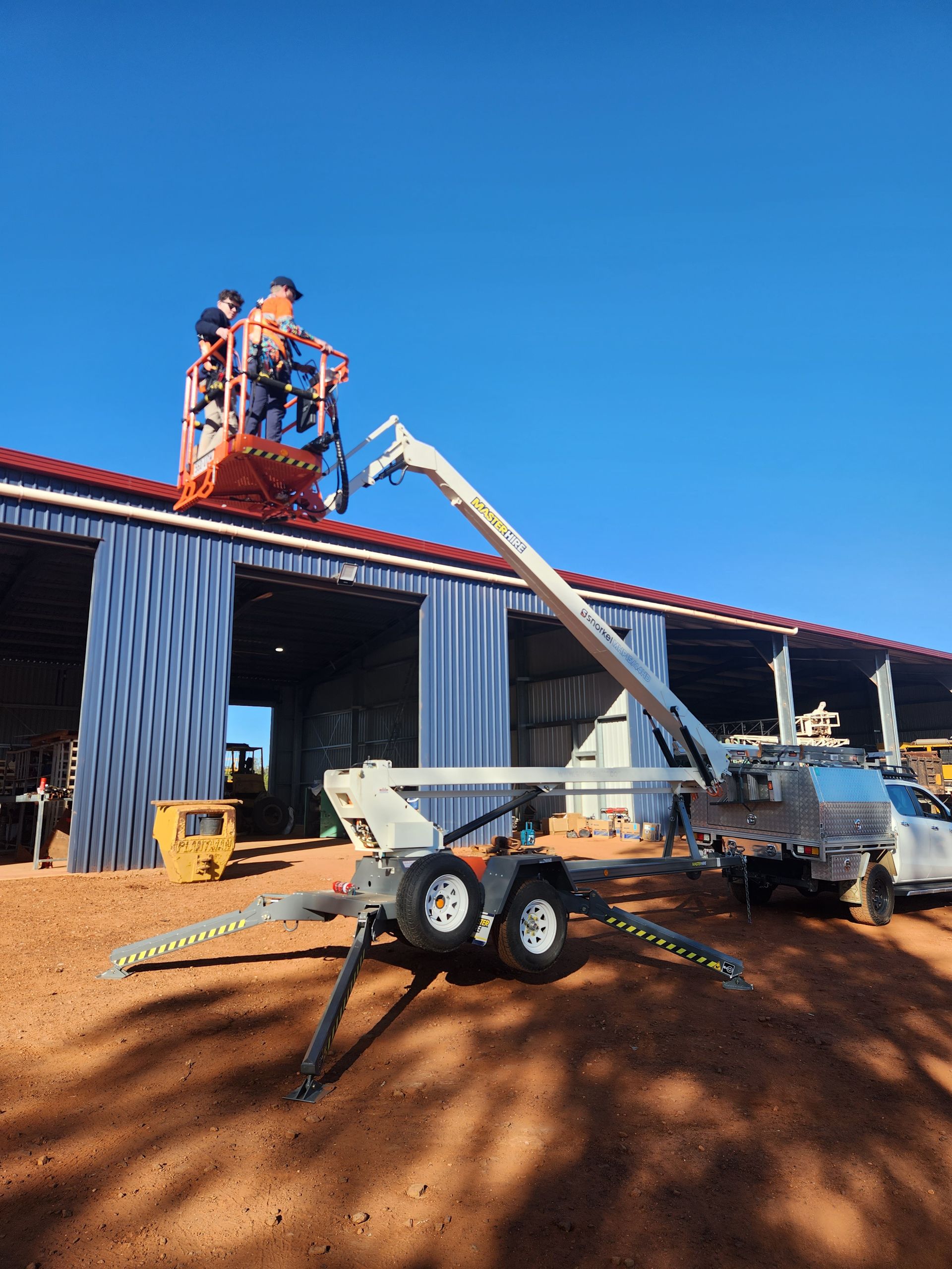 Workers in a Lift Are Working on the Roof of a Building on a Sunny Day — Frontier Security in Chinchilla, QLD