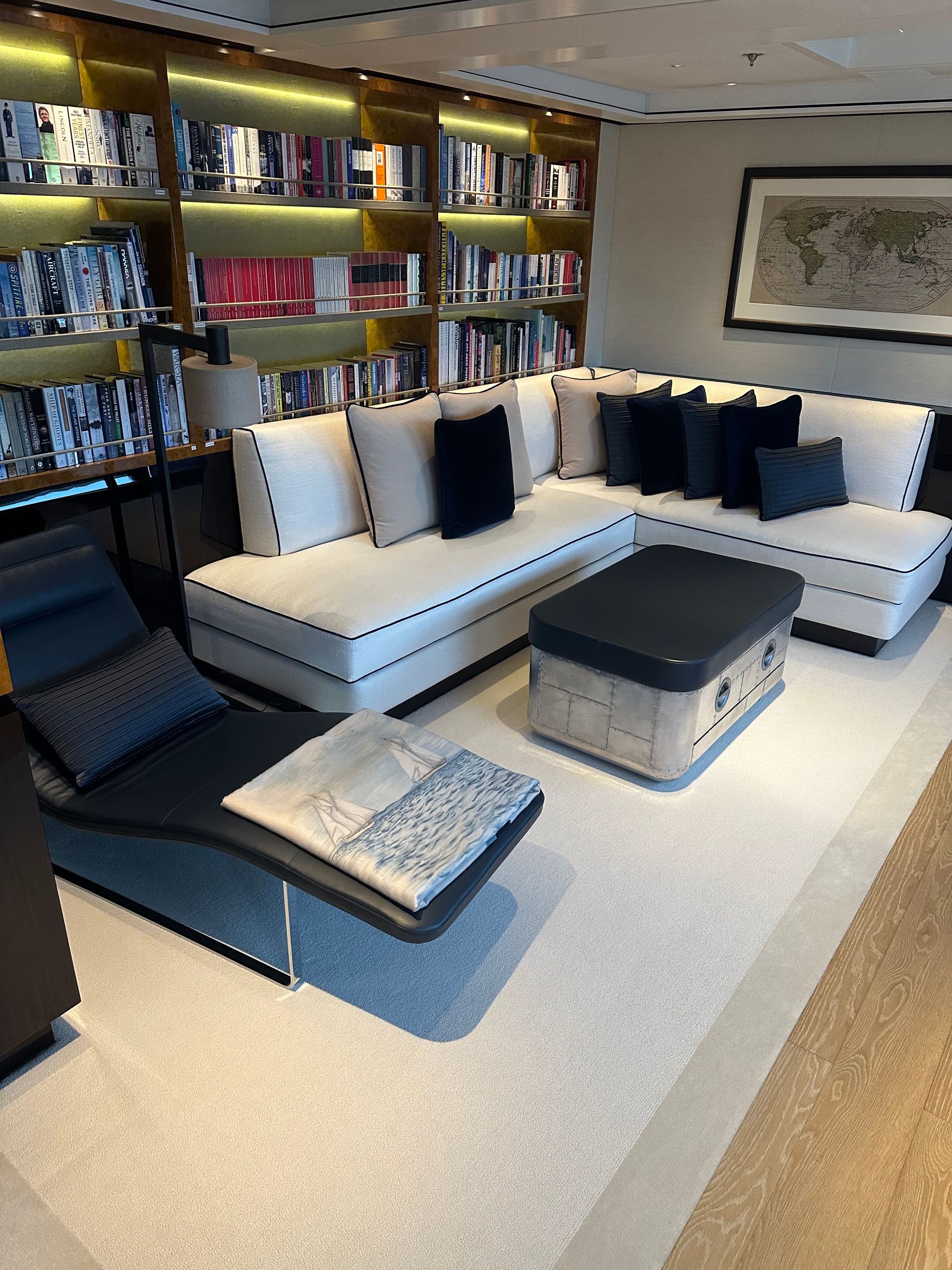 A person is cleaning a white leather couch with a vacuum cleaner.