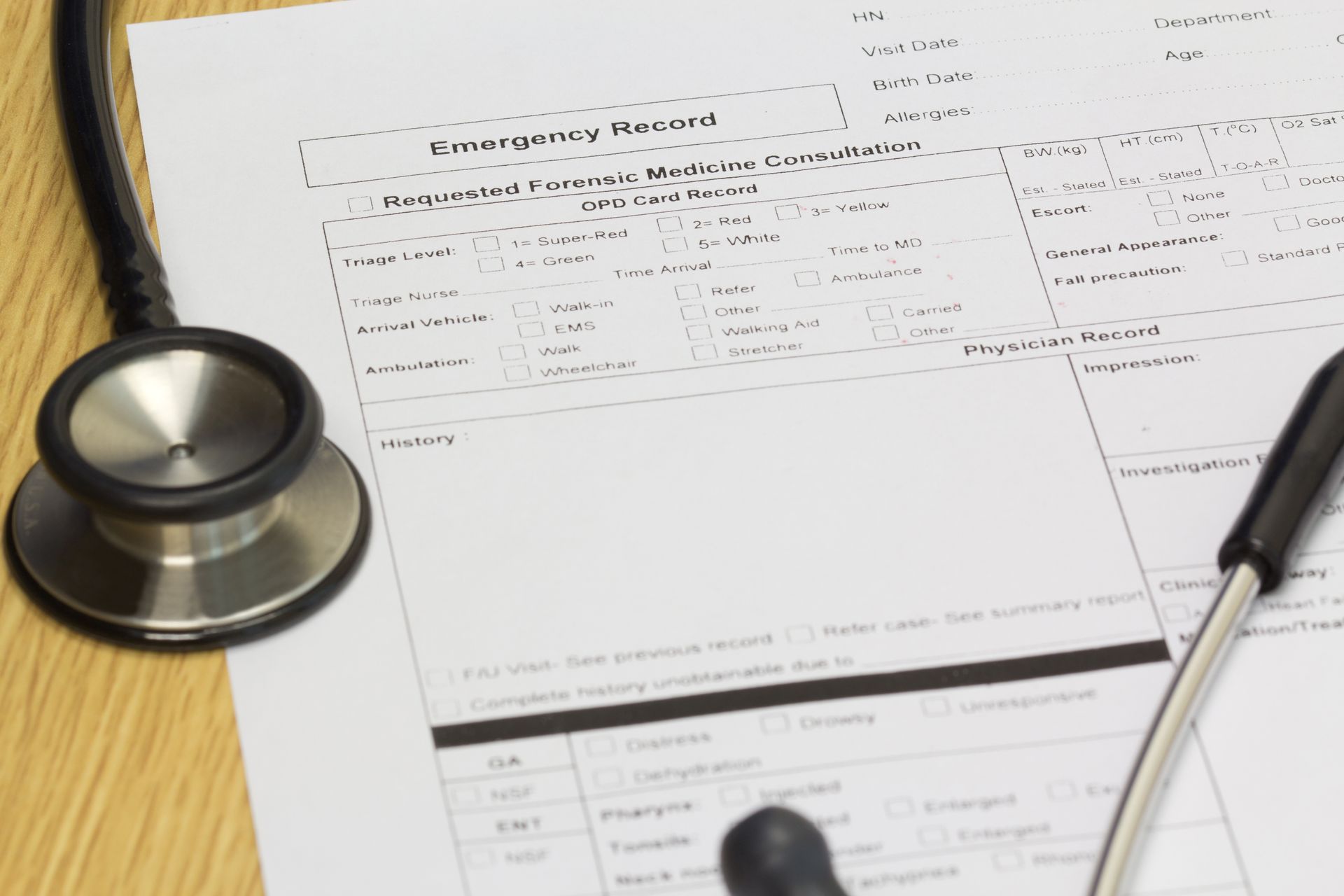 Stethoscope on a desk next to an emergency medical information form.