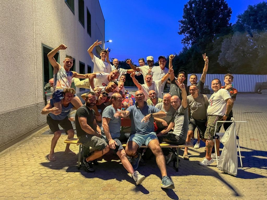 Un gruppo di persone posa per una foto davanti a un edificio.