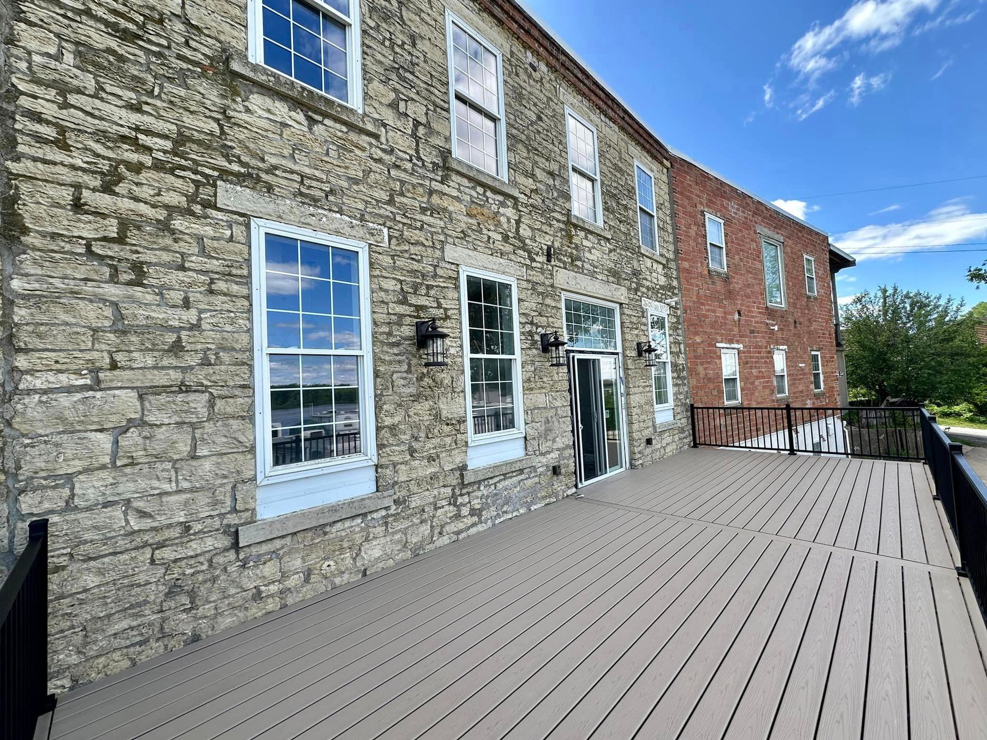 A large stone building with a wooden deck in front of it.