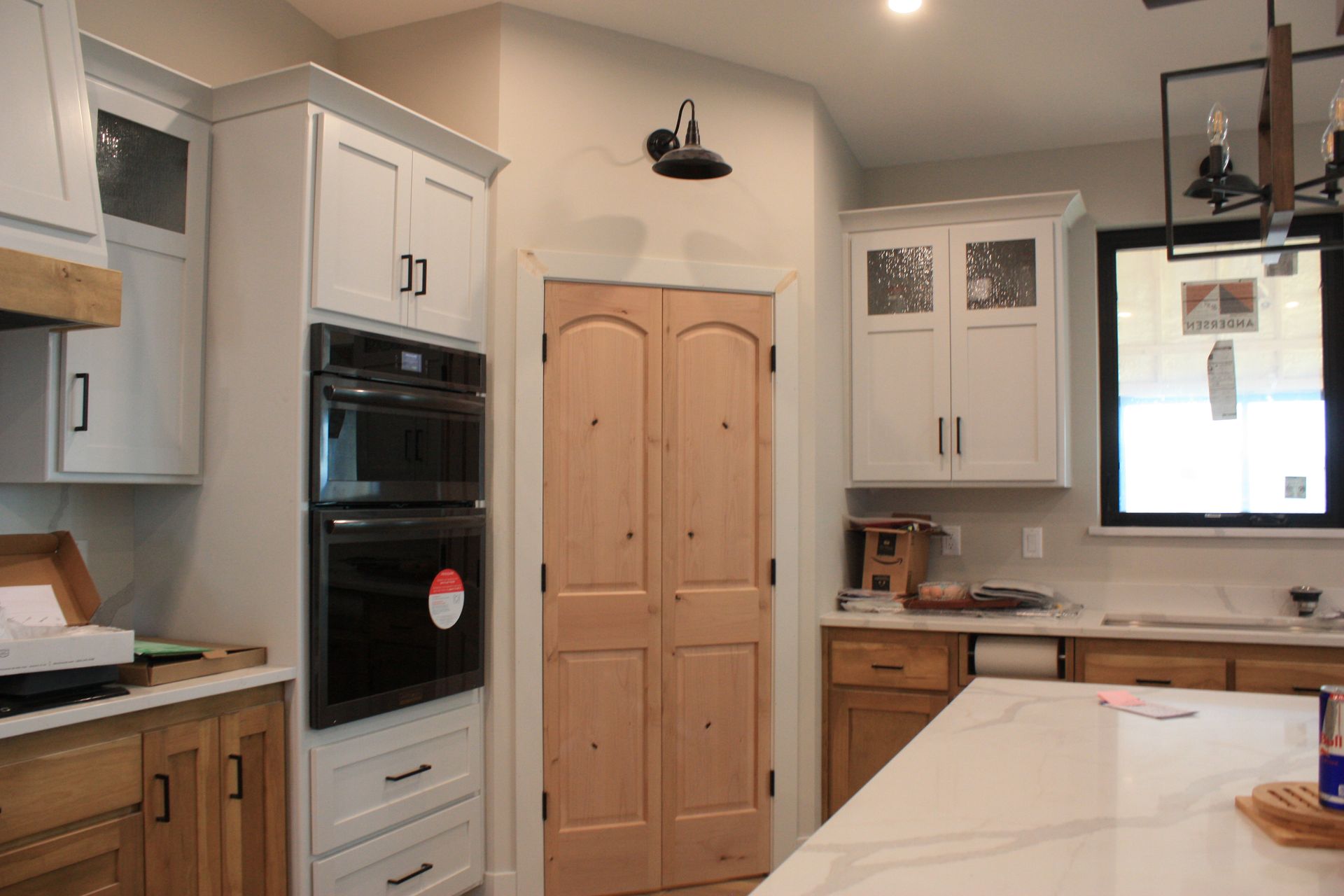 Custom Bellevue, IA kitchen with white and natural wood cabinets, double ovens, and a large island