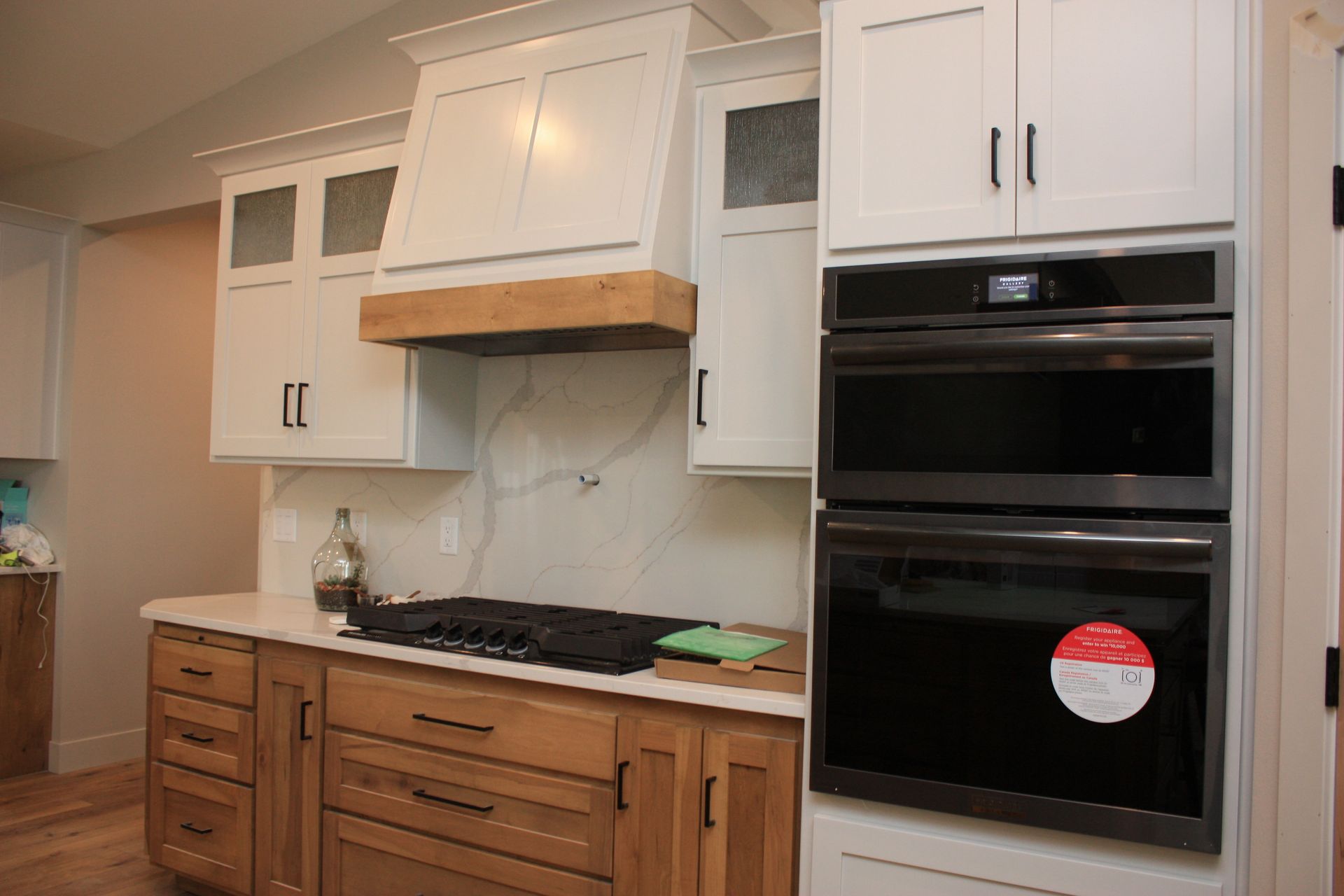 A kitchen with wooden cabinets , a stove top oven , and a microwave.