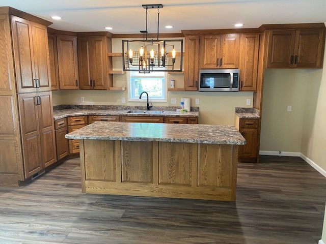 Custom kitchen remodel near Bellevue, IA with oak cabinetry, granite countertops, and a large center island