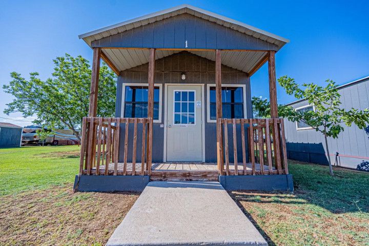 A small house with a porch and a walkway leading to it