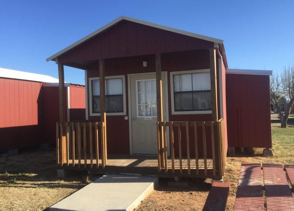 A small red house with a white door and porch