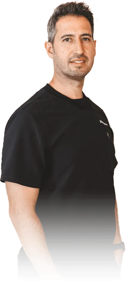 Man in black t-shirt looking at the camera, slight smile.