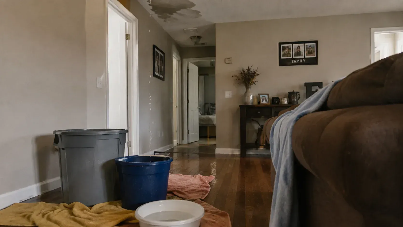 Living room buckets catching water: what should you do if your roof is leaking during a storm