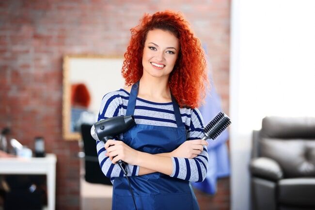Professional Hairdresser Holding A Blower And Hairbrush — KD's Hair Design In Soldiers Point, NSW