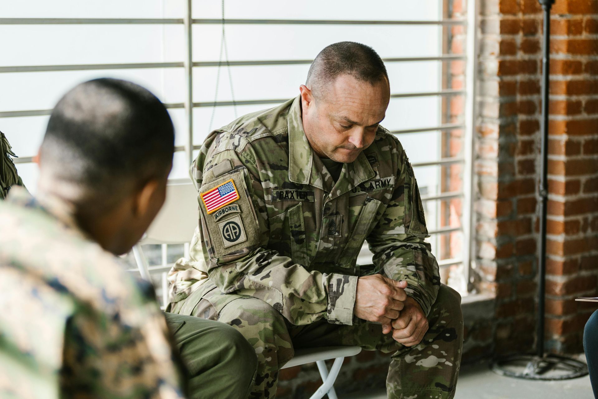A group of soldiers are sitting in a circle talking to each other.