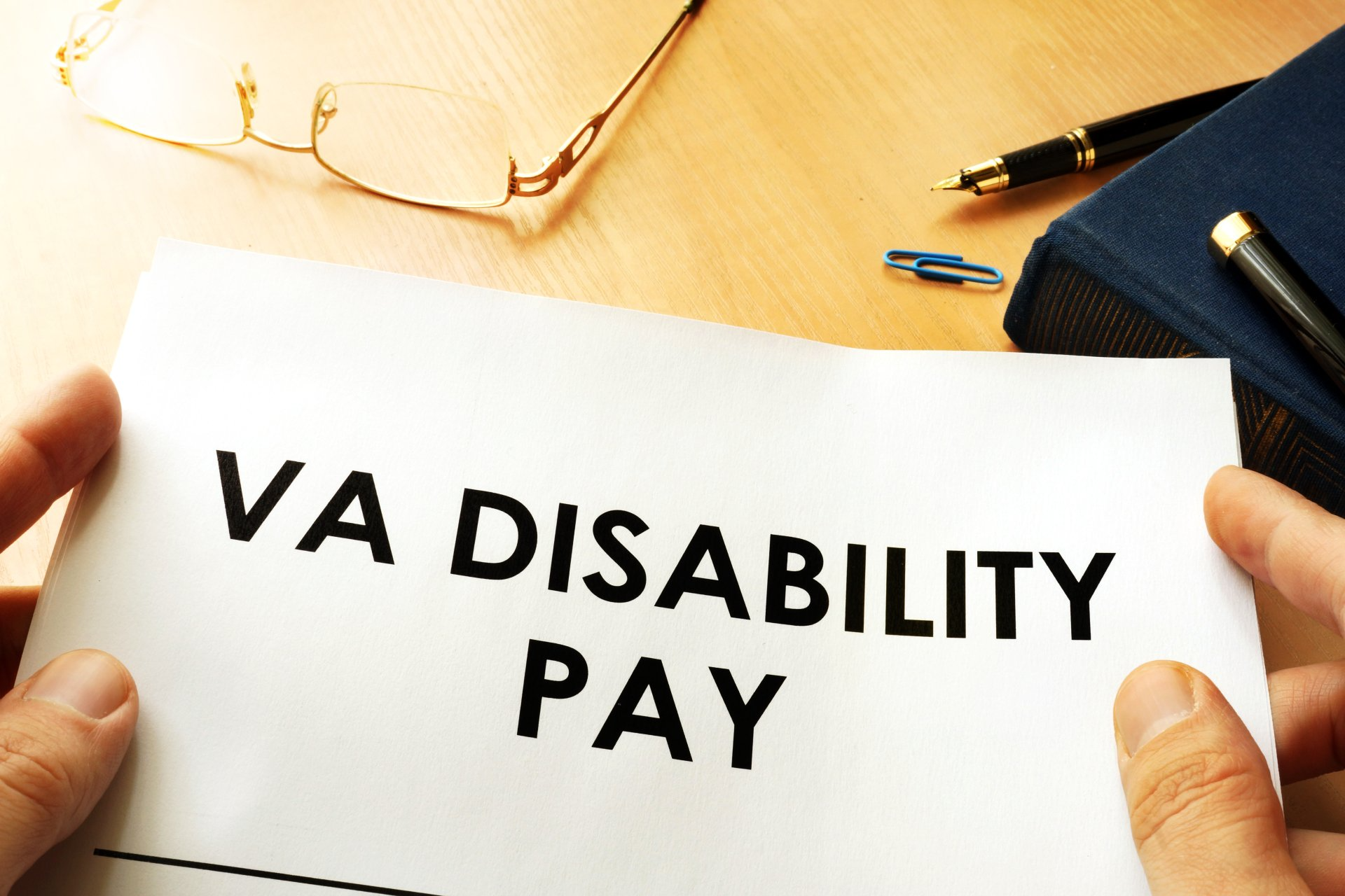 A person is holding a piece of paper that says va disability pay