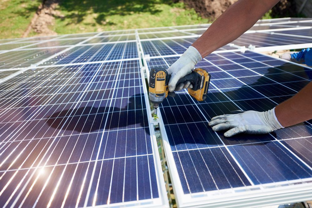 Installing Solar Panels On A Roof With A Drill — Max Fox Electrical in Narrabri, NSW