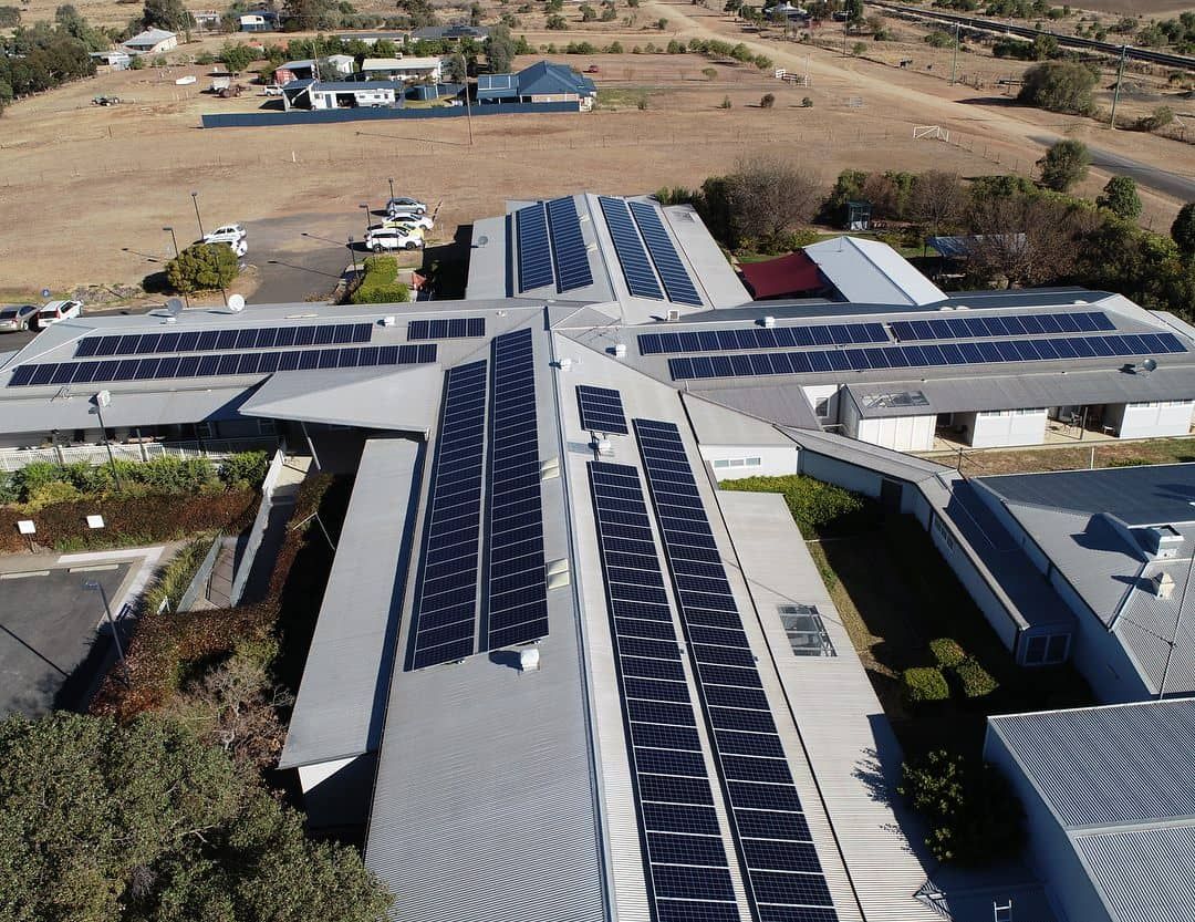 An Aerial View of A Building with Solar Panels on The Roof — Max Fox Electrical in Taminda, NSW