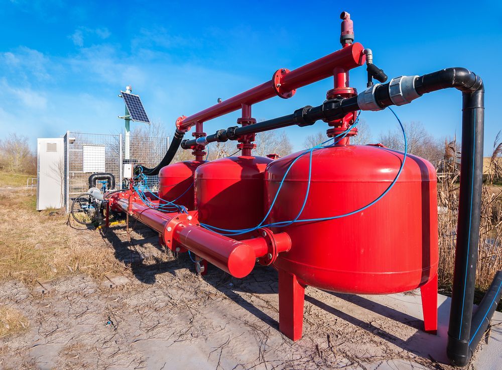 Red Industrial Pump and Piping Beside Large Red Tanks — Max Fox Electrical in Taminda, NSW