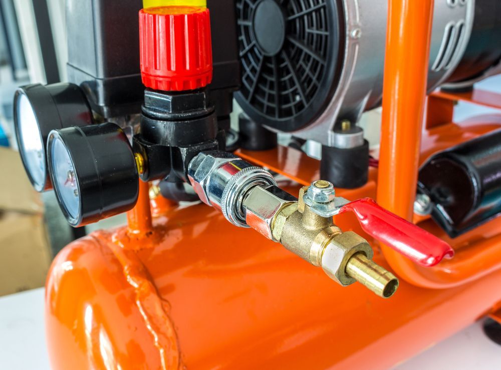 Close-up of an Orange Air Compressor With Pressure Gauge — Max Fox Electrical in Quirindi, NSW