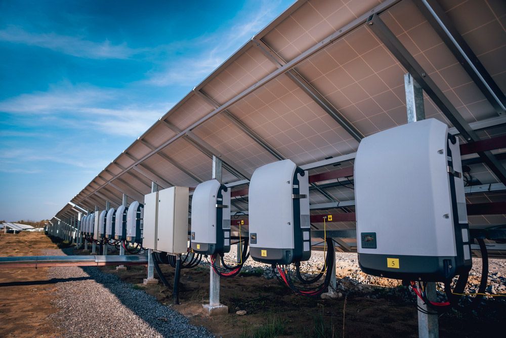 A Row Of Solar Panels And Inverters In A Field — Max Fox Electrical in Armidale, NSW