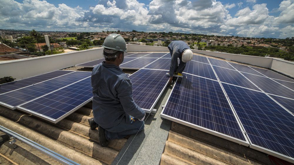 Two Men Installing Solar Panels on Roof