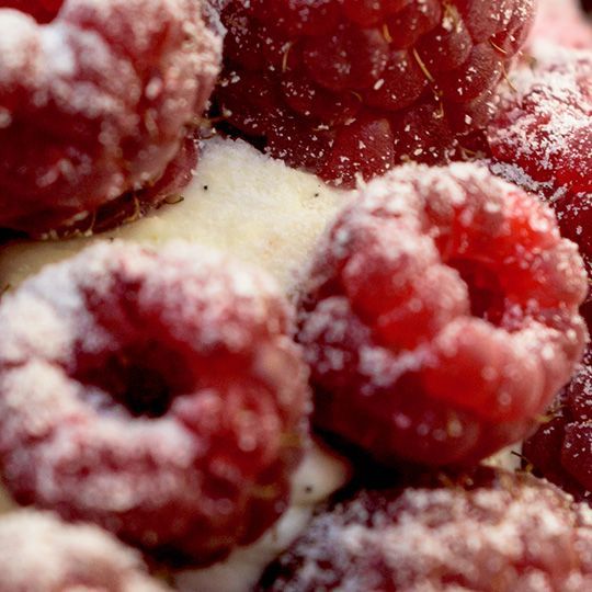 Un gros plan de framboises recouvertes de sucre en poudre