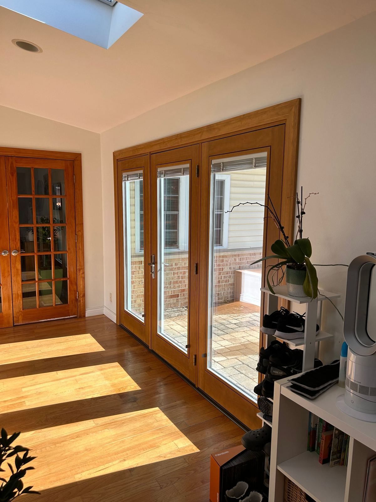 Three-panel wood-finish French patio door in a sunroom