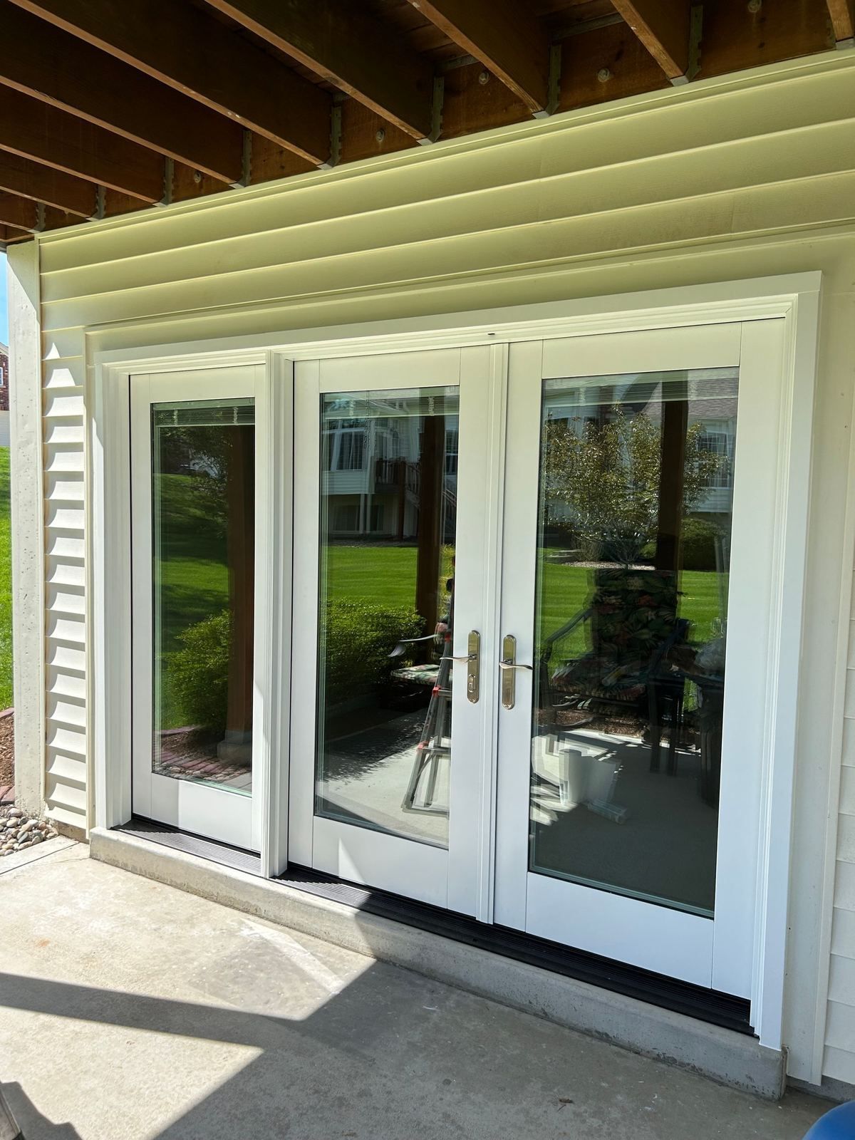 White French patio doors with a sidelight on a walkout basement under a deck