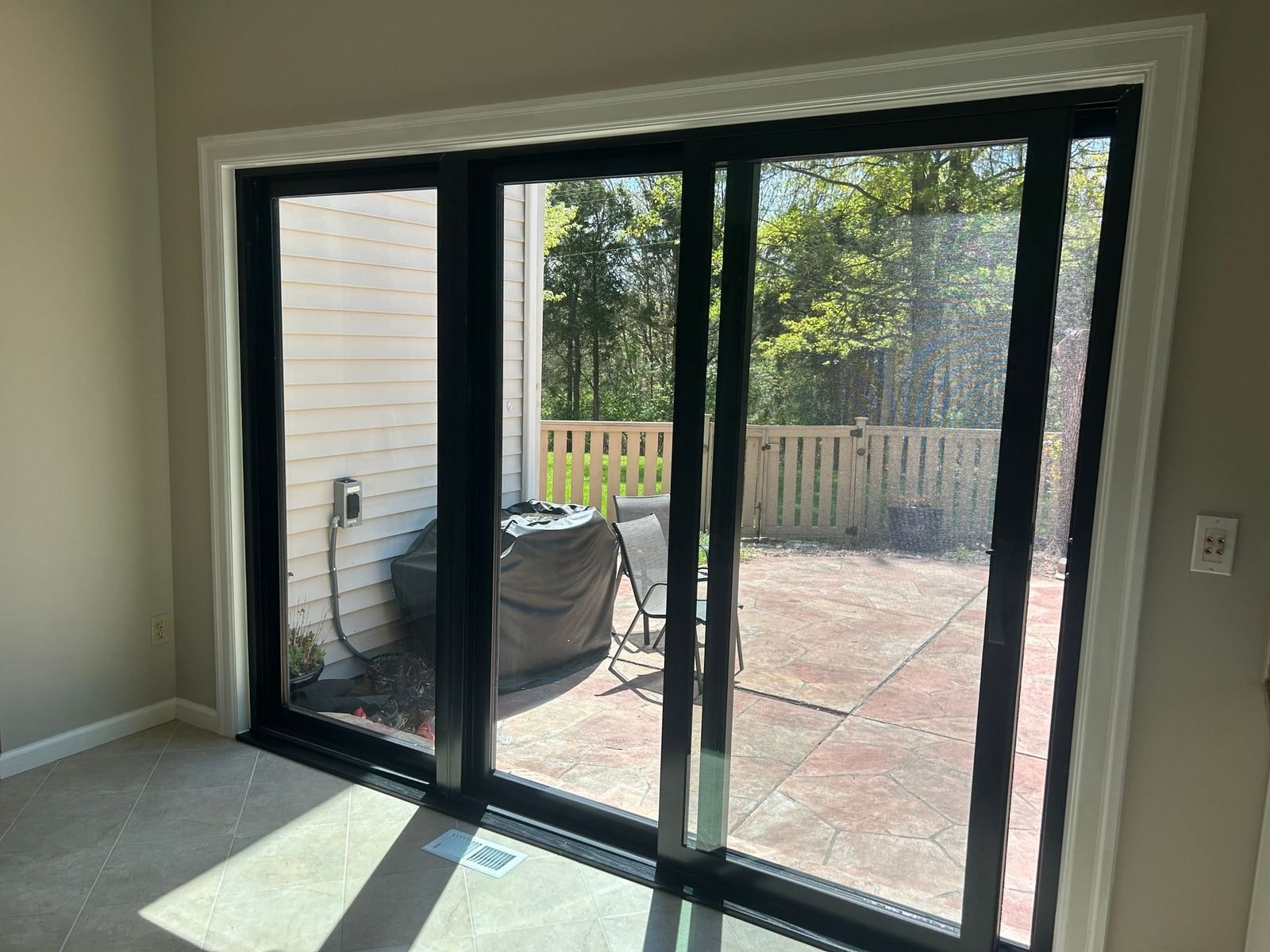Black-framed sliding patio door opening onto a stamped concrete patio