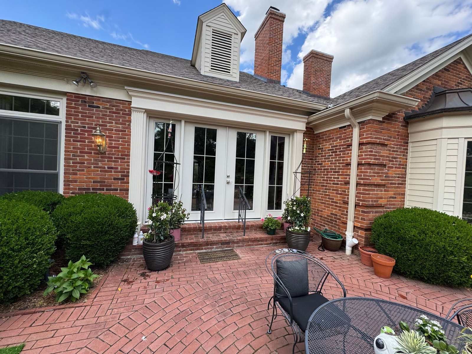 White French patio doors with sidelights opening onto a brick patio