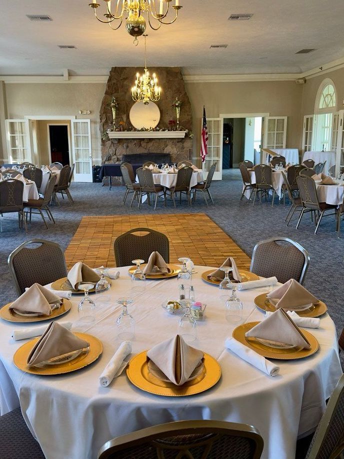 A large room with tables and chairs set up for a wedding reception.