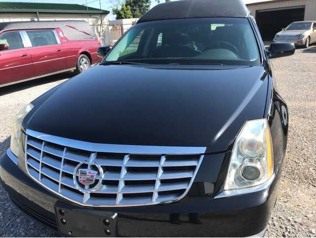 A black cadillac is parked in a parking lot