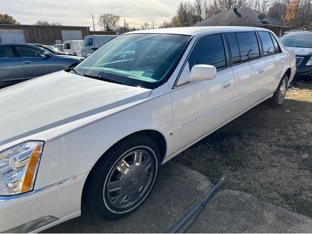 A white limousine is parked in a parking lot.