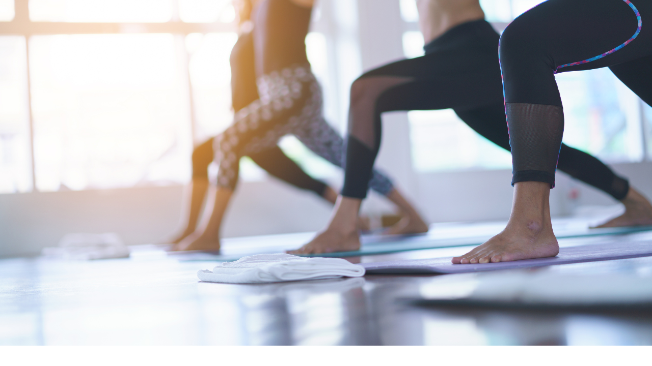 A group of women are laying on their stomachs on yoga mats.