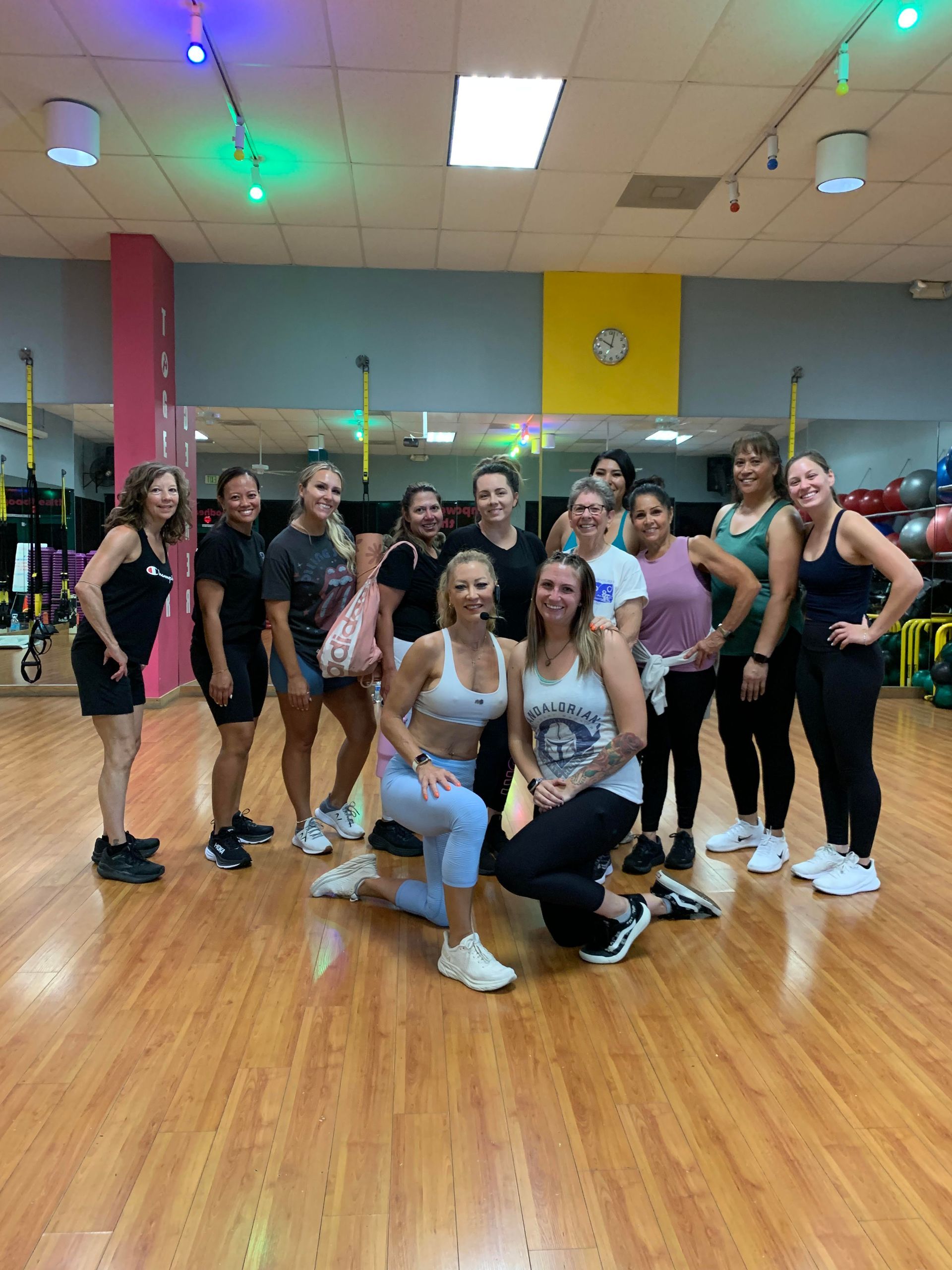 A group of women are posing for a picture in a gym.