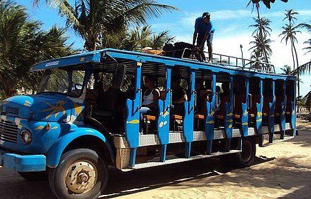 Um ônibus azul com um homem em cima dele