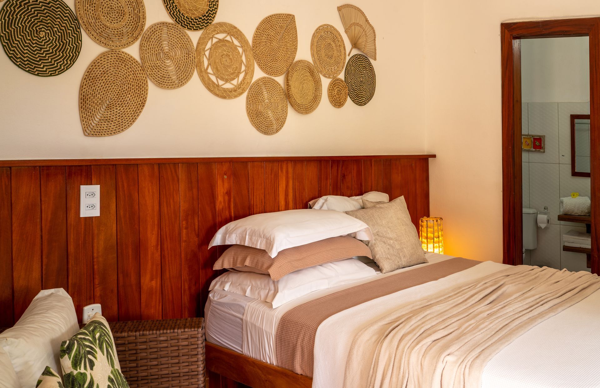 Um quarto com uma cama, sofá e cestos na parede.