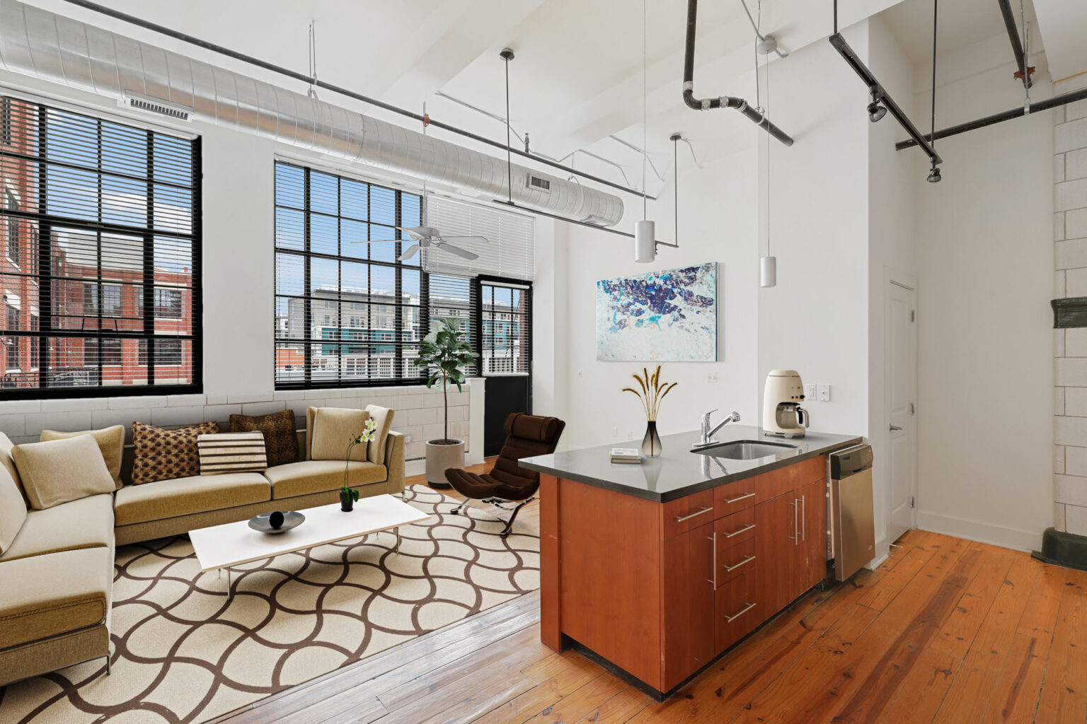 A living room with a couch, coffee table, and kitchen.